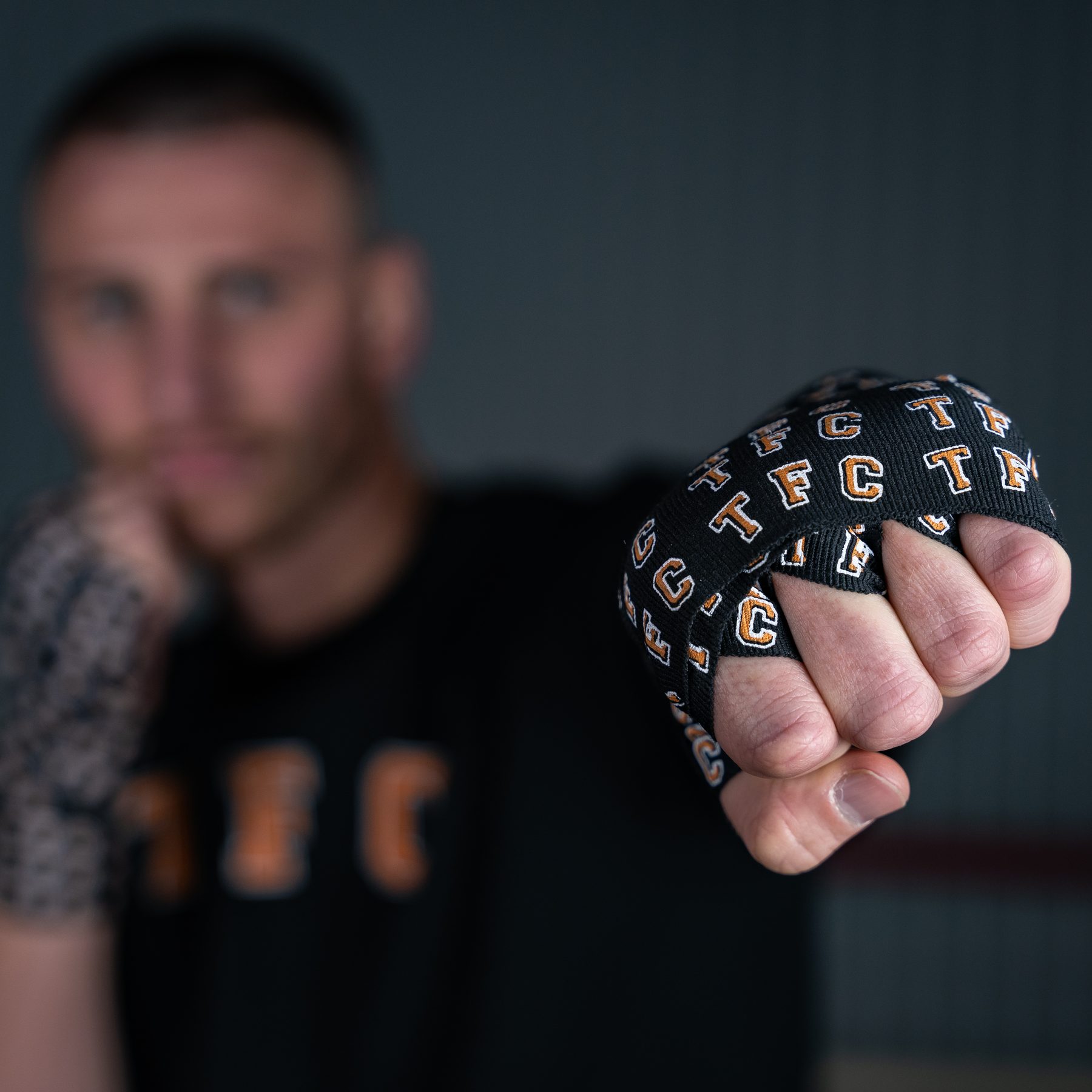 Close-up of a wrapped fist in custom TFC-branded hand wraps
