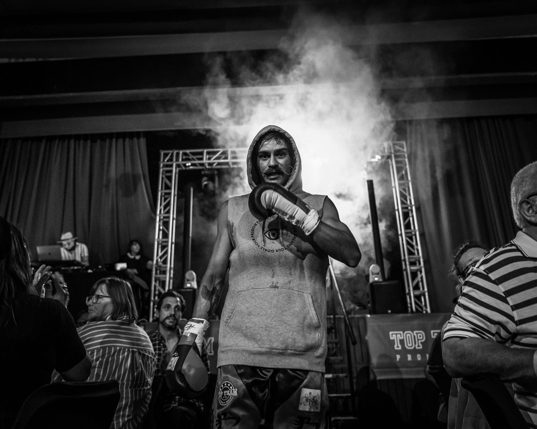 Boxer walking out through smoke and stage lights before his fight